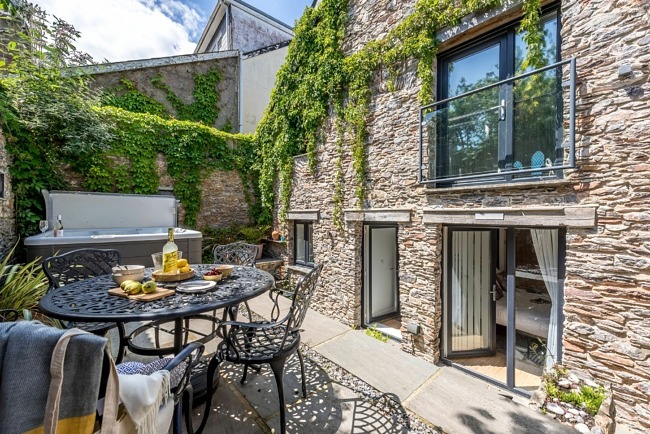Outdoor space with seating on the patio with hot tub - The Old Chapel