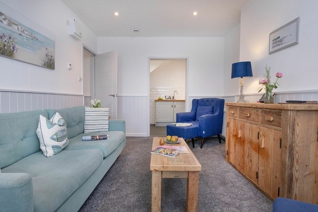 Lounge with sofa and coffee table leading to kitchen - Crabby Cove