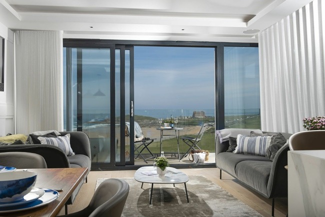 Lounge with sofas, coffee table and TV leading to balcony with French doors  - Number 9 Fistral House 