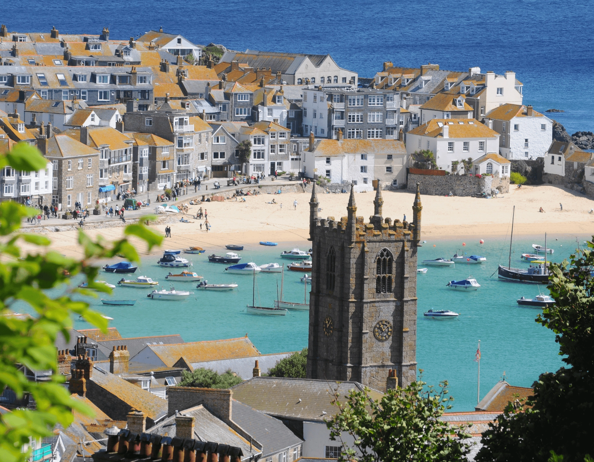 Views over the town and turquoise water of St Ives harbour and beach in Cornwall