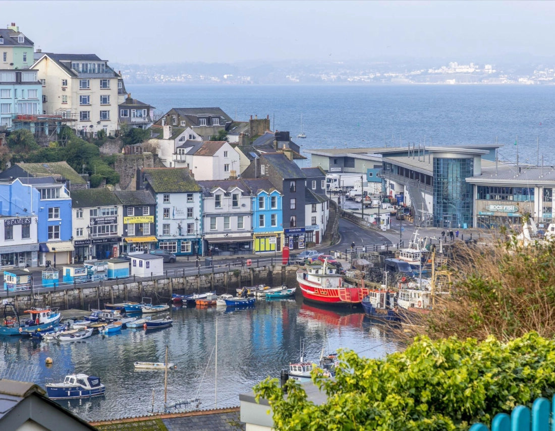 View over Brixham Harbour and brightly coloured cottages in Torbay, South Devon