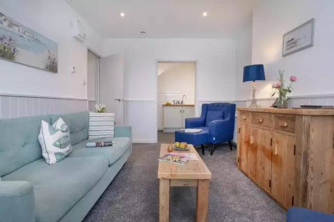 Lounge with sofa and coffee table leading to kitchen - Crabby Cove